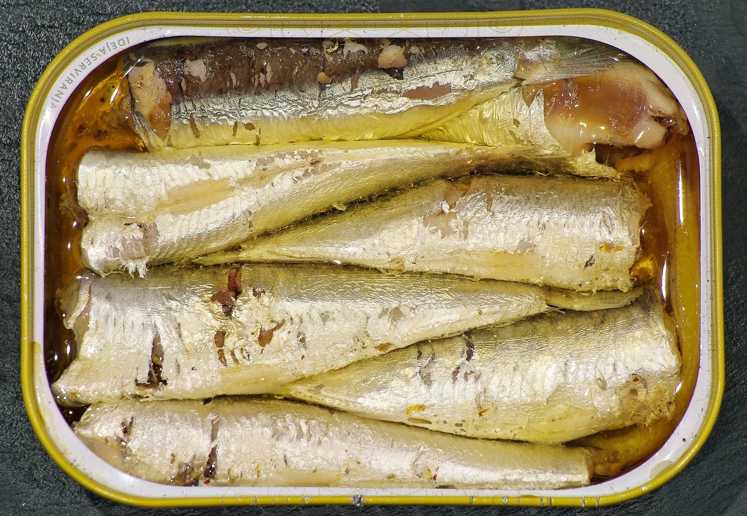 Geöffnete Dose Vintage-Sardinen in goldenem Olivenöl
