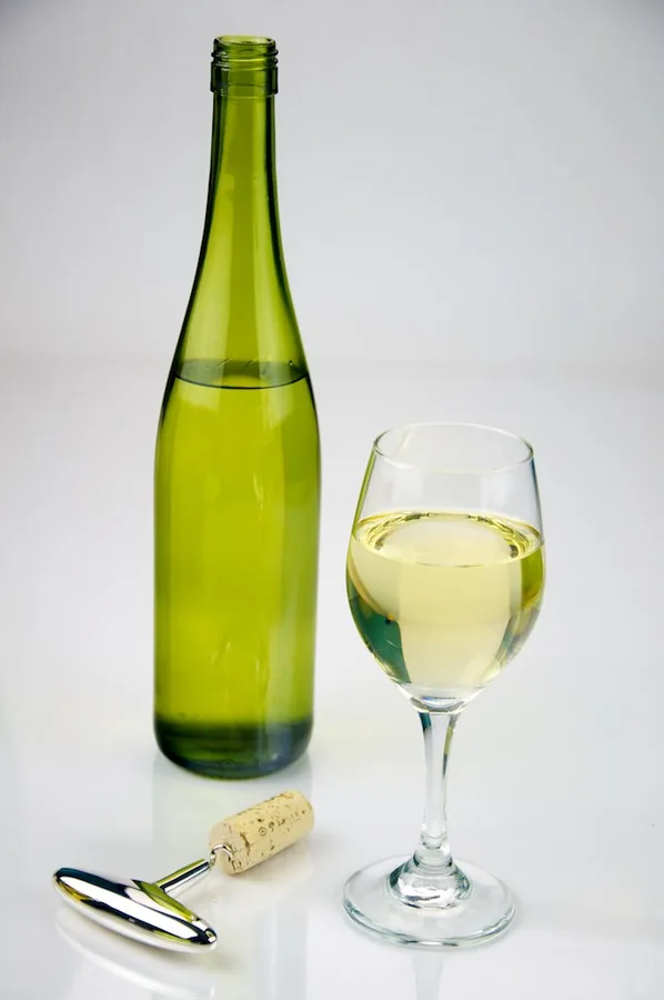 Glass of white wine paired with aged canned trout